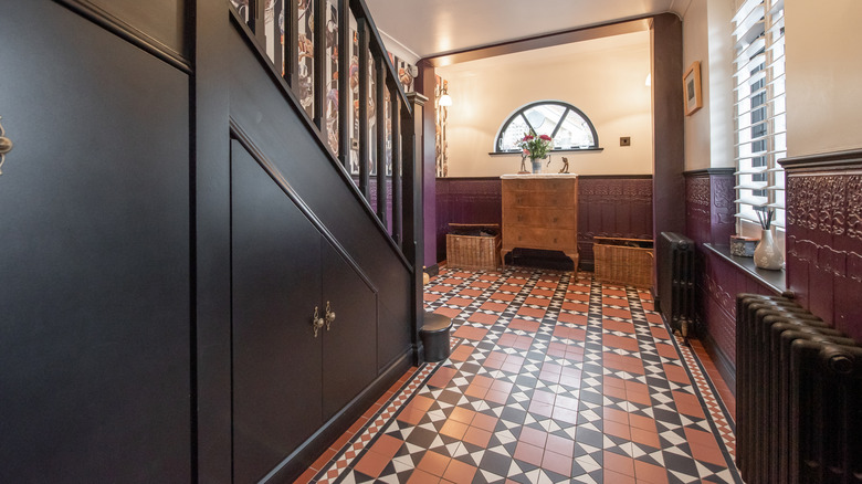 Entryway with vibrant tiles and brown wood furniture.