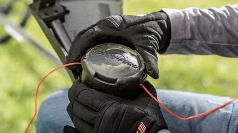 Gloved hands are in position on a Speed-Feed trimmer head