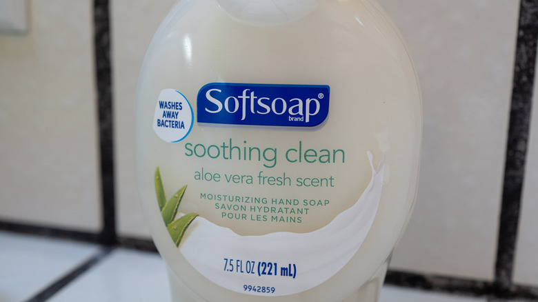 A bottle of Softsoap soothing clean aloe vera fresh scent rests on a bathroom countertop