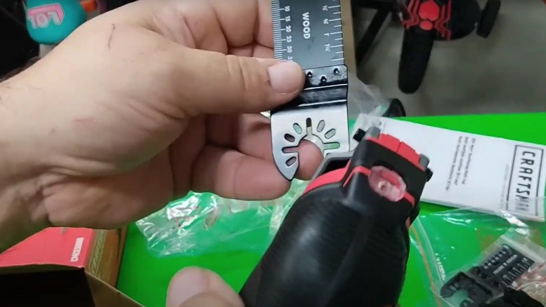 person holding oscillating tool blade