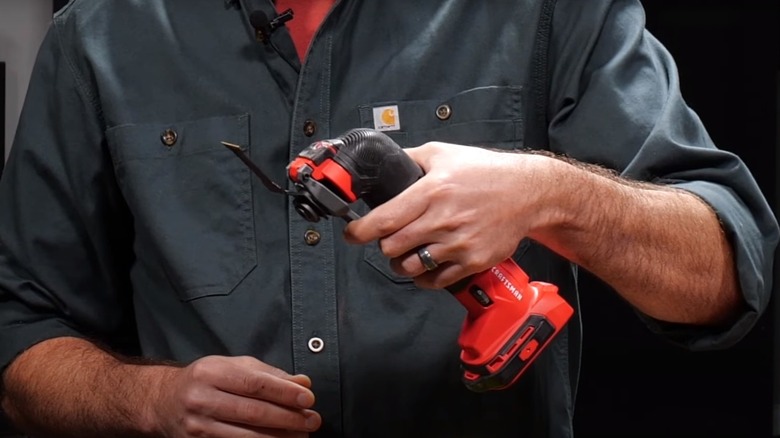 man holding an oscillating tool