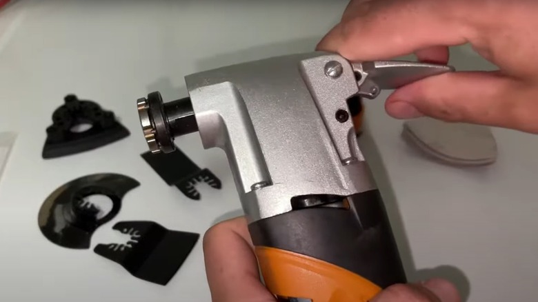 person changing blades in an oscillating tool