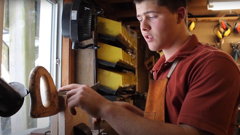 man using a clamp to hold saw blade