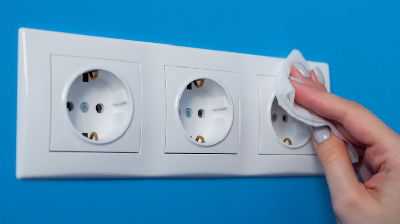 woman cleaning electric socket