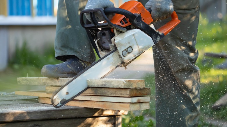 cutting wood with chainsaw