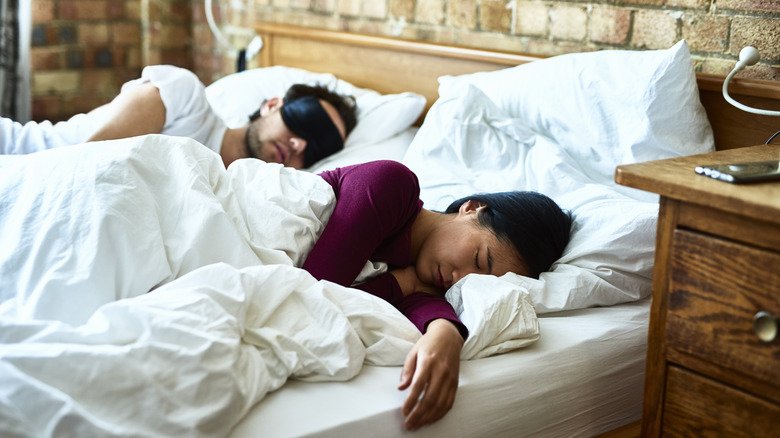 Two people sleeping on a bed