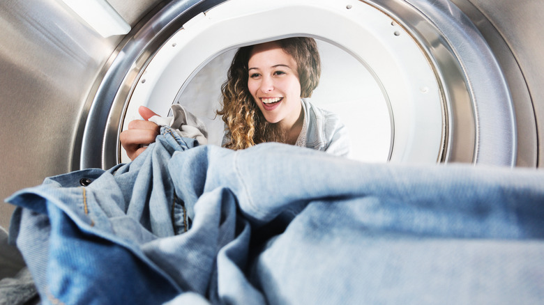 Woman removing jeans from dryer