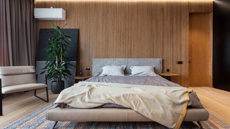 A bedroom with wall panelling and thick curtains to keep noise out.