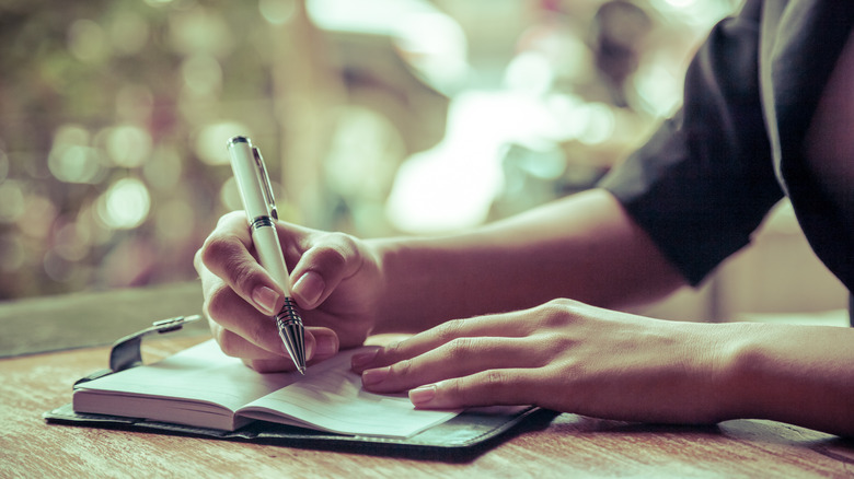 Woman writing in garden journal