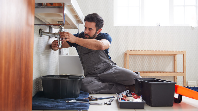 man fixing broken sink