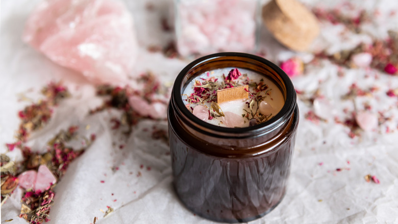 candle with flower pieces and crystals