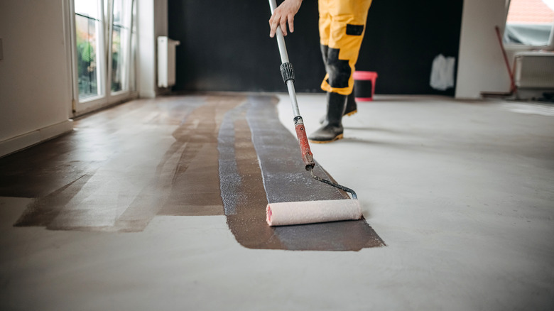 worker applying stain on fresh concrete floor