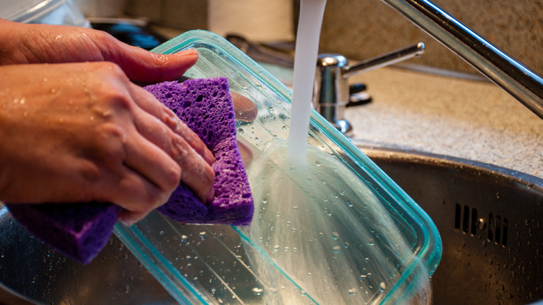 person washing plastic container