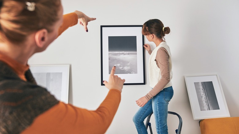 mom and daughter hanging pictures