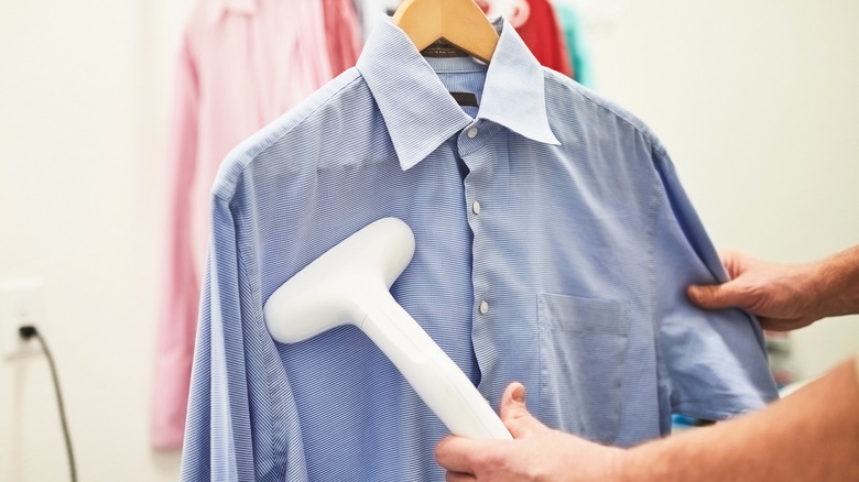 person using steam on shirt