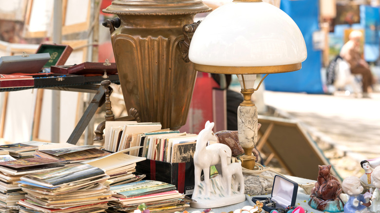 Thrifted lamp on desk full of pamphlets and figurines