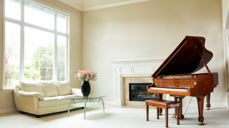 wooden grand piano and large window