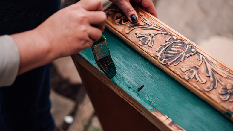 Hands repainting antique wood