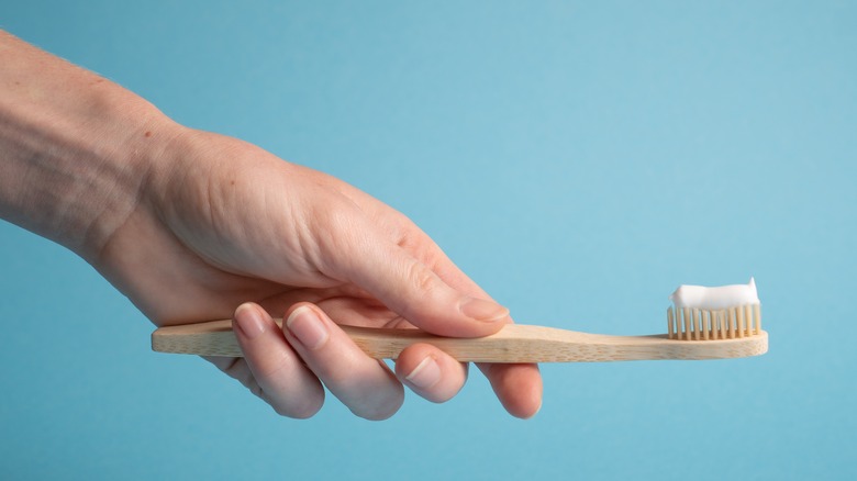 Hand holding toothbrush with toothpaste