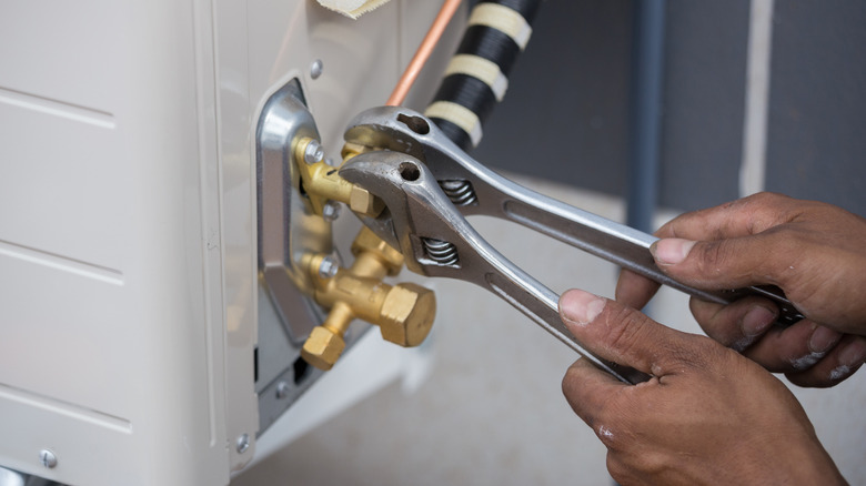 Man adjusting AC valves