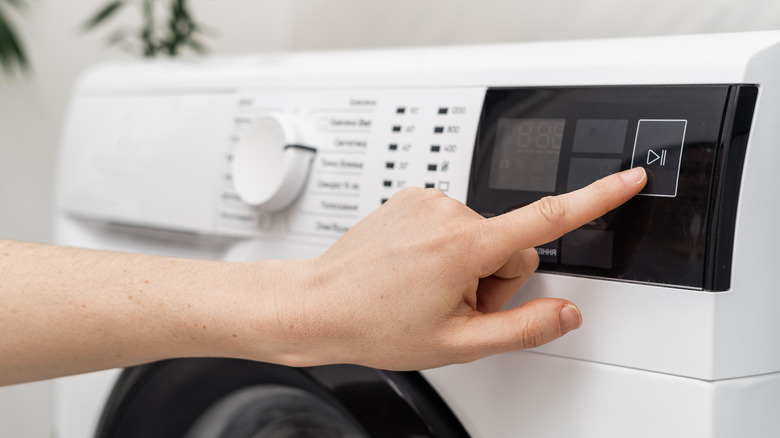 Woman pressing buttons on washer