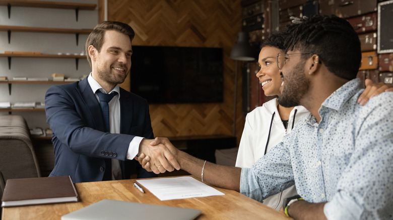 Couple shaking hands with Realtor