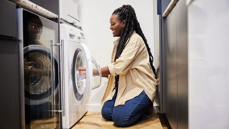 Woman putting clothes in dryer