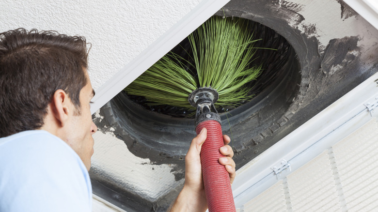 A man cleaning an air duct