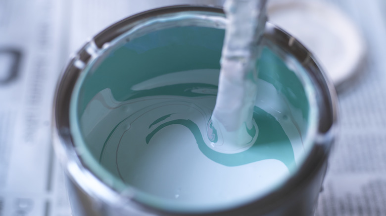 Stirring teal paint