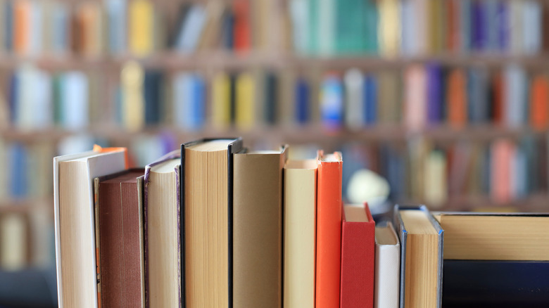 Close up of standing books set against a background of a full bookshelf