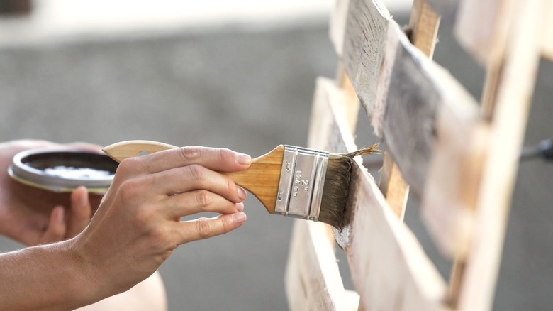 person painting upright pallet