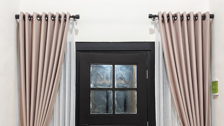 Door way with black rods and curtains on either side