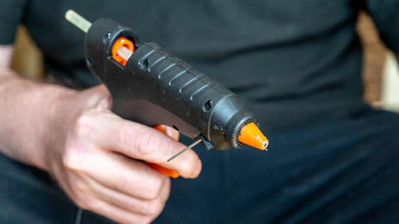 person holding hot glue gun