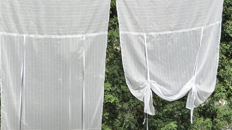 Sheer white DIY tie up curtains on a clothesline