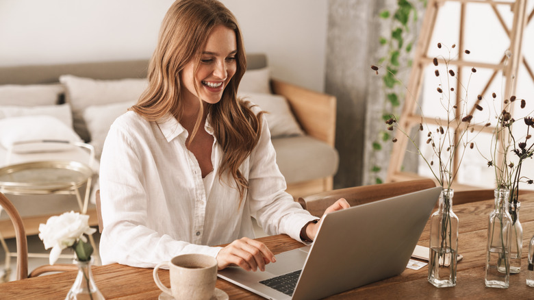 happy woman typing on laptop