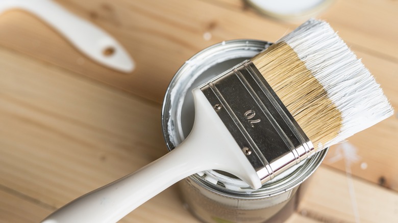 white paintbrush on paint can