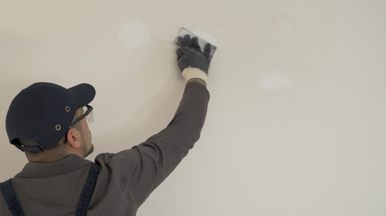 man sanding drywall