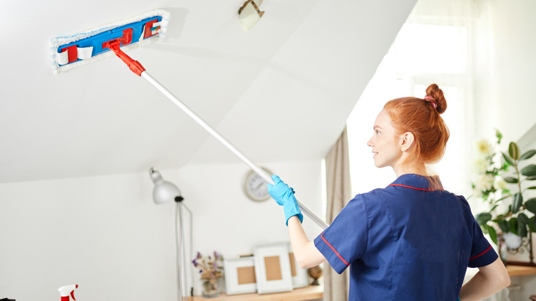 Dusting the ceiling with mop