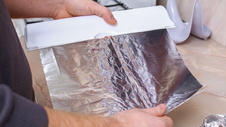 Man rolls out aluminum foil