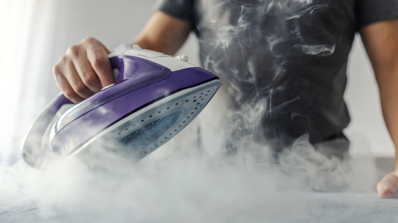 man ironing with billowing steam