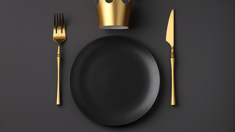 black dish with gold cutlery