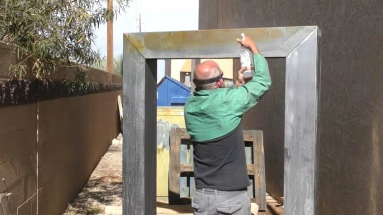 man sprays peroxide on metal