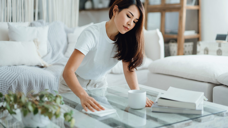 Woman wiping glass table