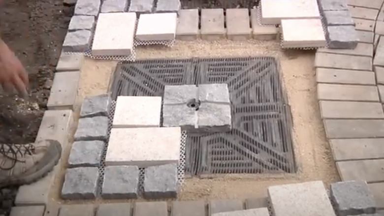 An in-ground reservoir for a fountain built into a paver patio