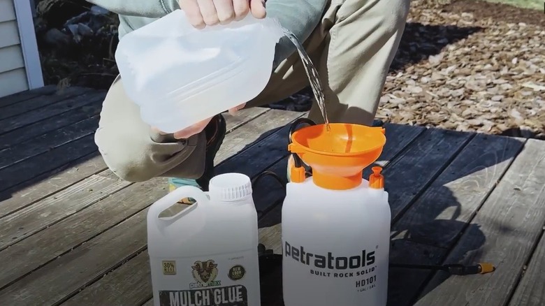 person mixing mulch glue and water in a sprayer