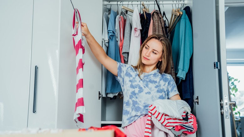 woman sorting clothes in closet