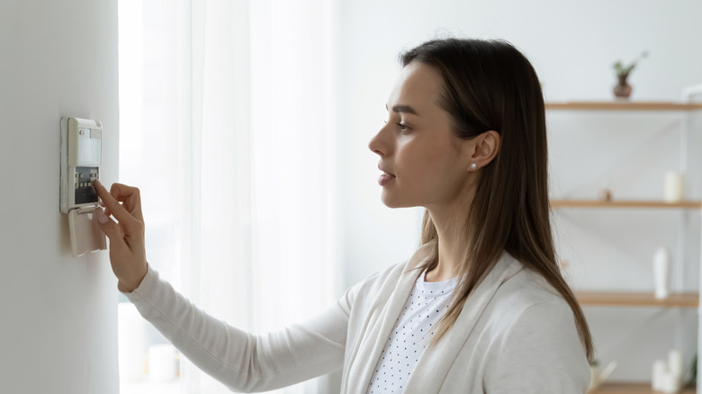 person adjusting thermostat