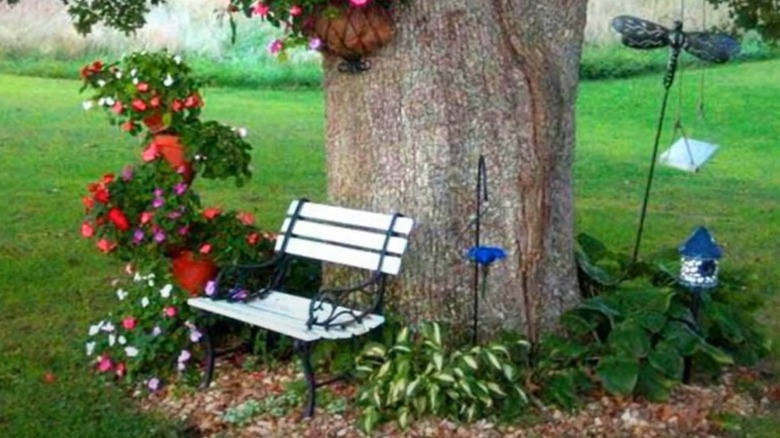 small white bench under a tree