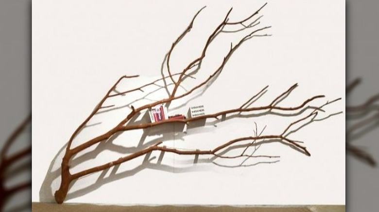 Branch with books mounted to wall