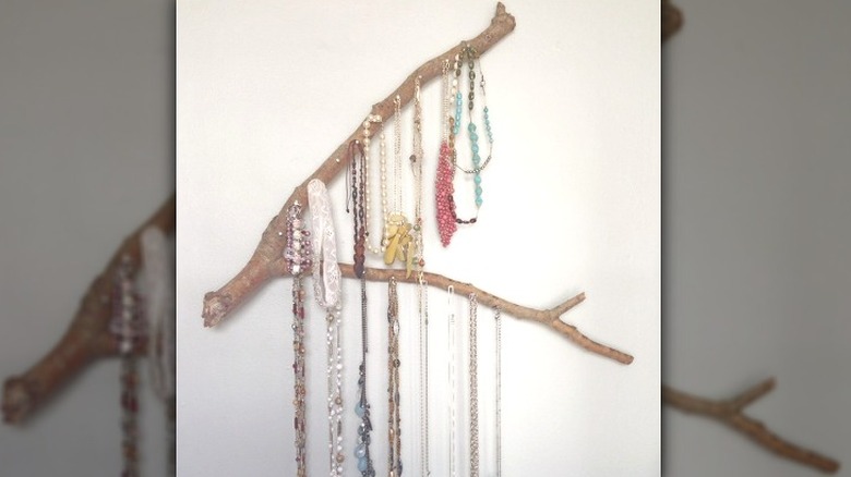 Pronged stick holding draped necklaces